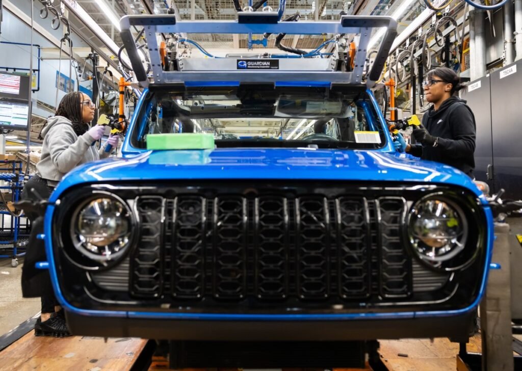 Production operators at the Toledo Assembly Complex secure the windshield of the 2024 Jeep Gladiator into position.