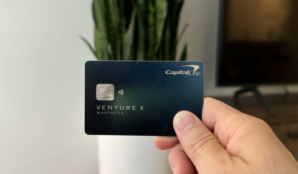 Capital One Venture X Business Card Review: Is It Worth It? Nomadic Matt holding up his Capital One Venture X business card