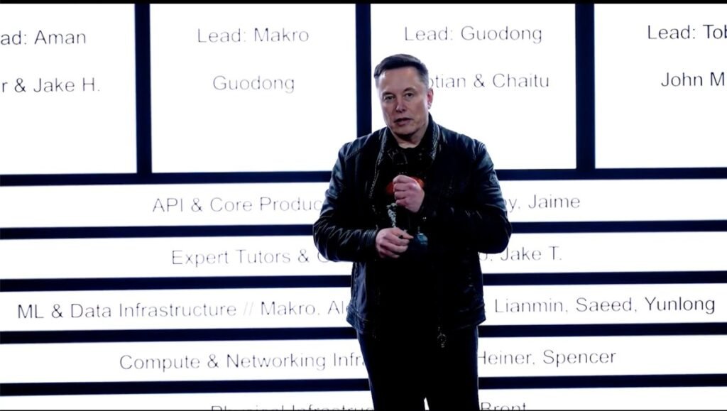 Elon Musk stands in front of xAI's new org chart
